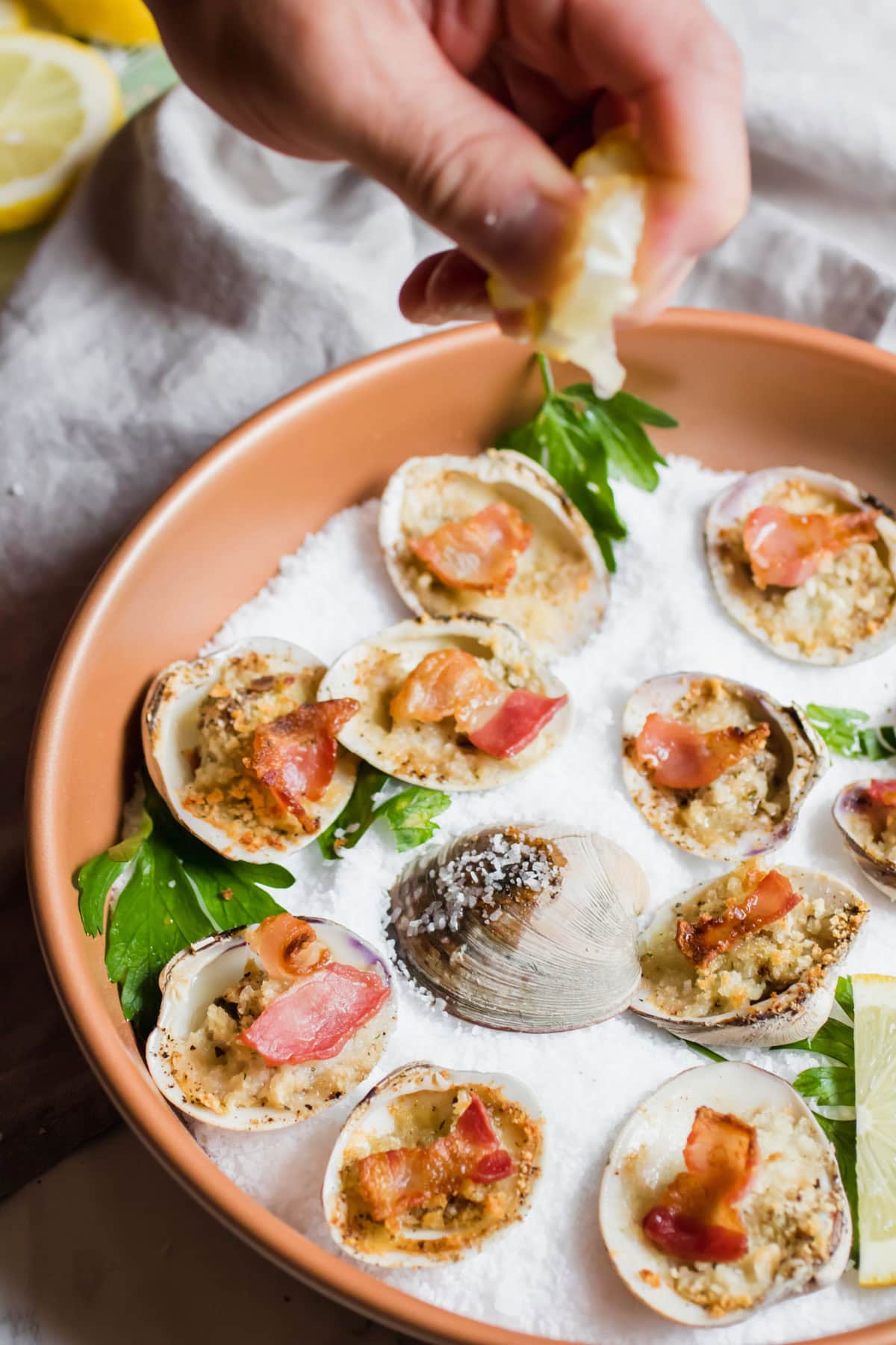 squeezing lemon juice on clams