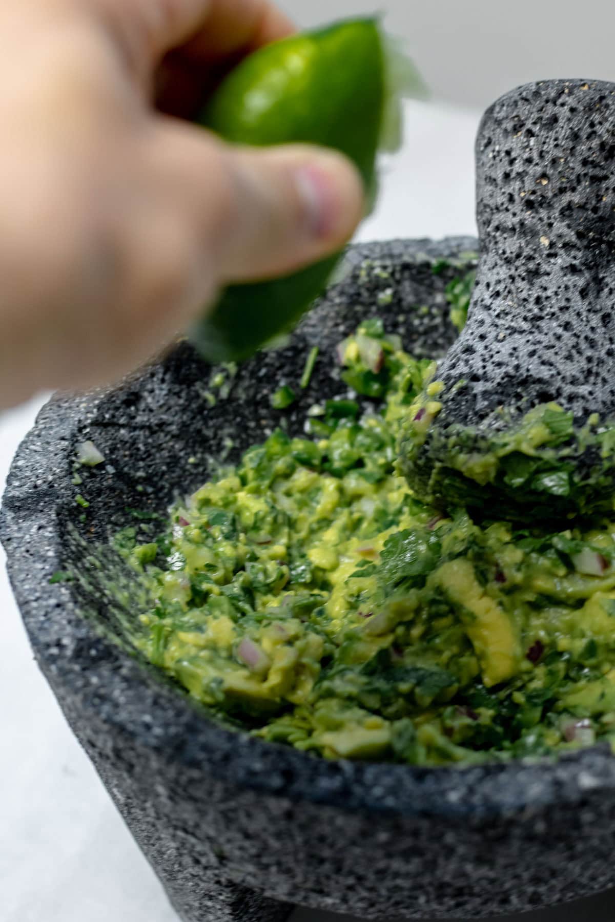 adding lime juice to avocado mash