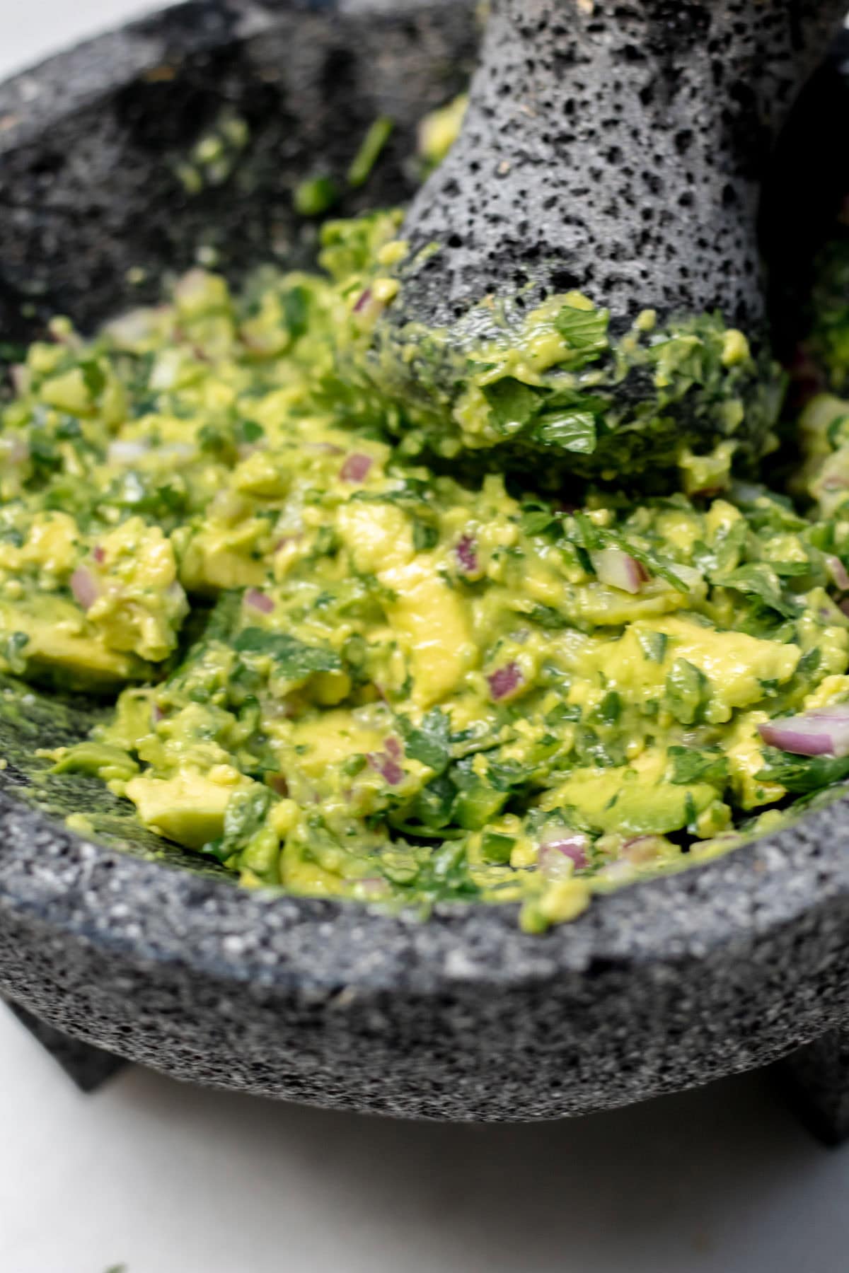 close up of guac in a mortar