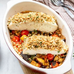 baked halibut with roasted eggplants in a pan