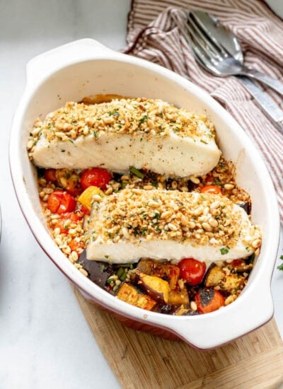 baked halibut with roasted eggplants in a pan