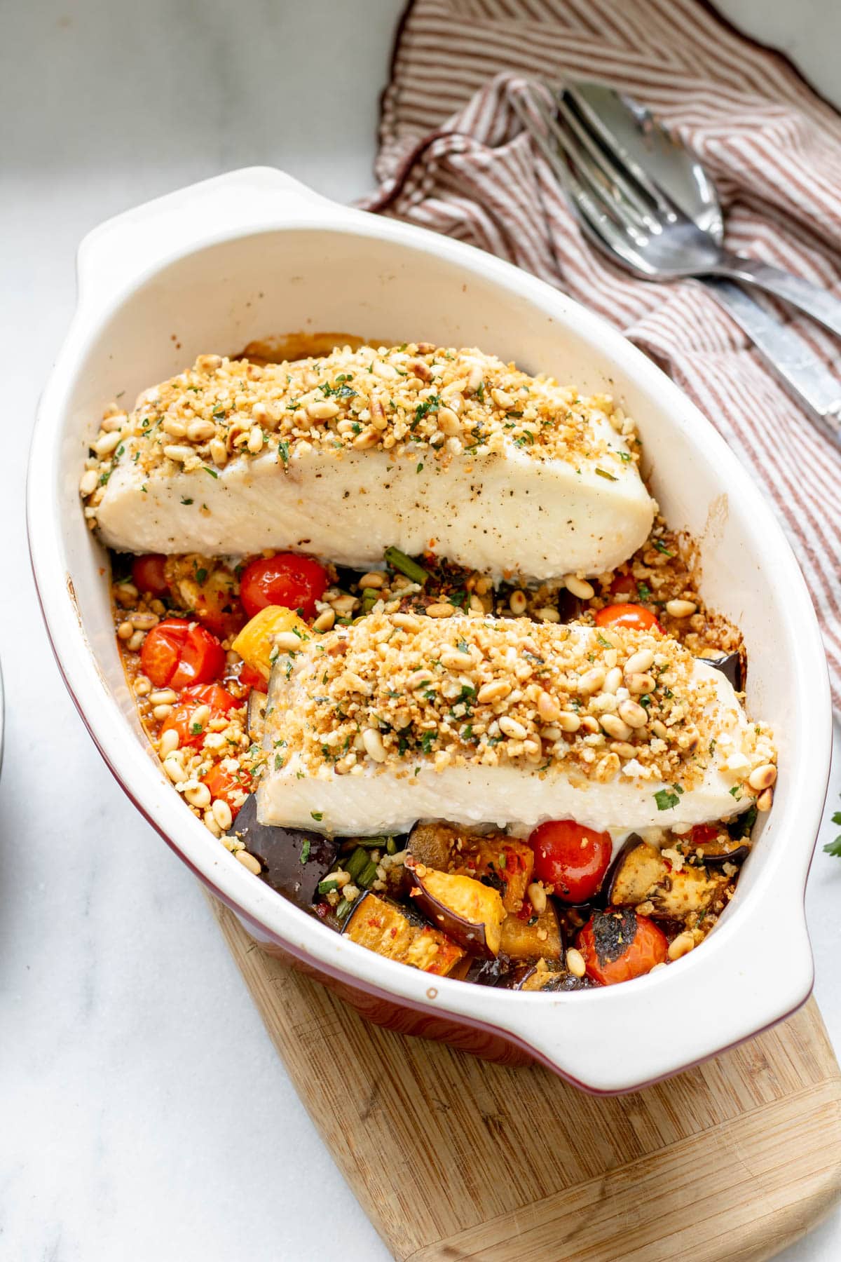 baked halibut with roasted eggplants in a pan
