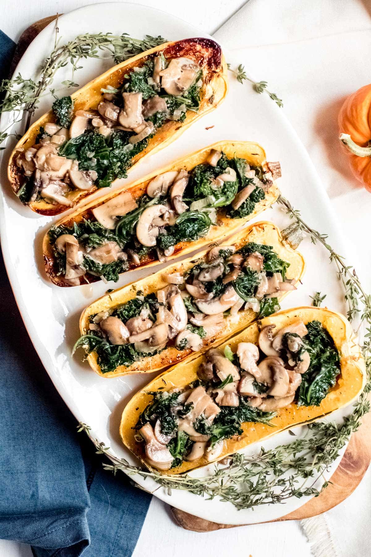 Creamy Kale and Mushroom Stuffed Delicata Squash halves on a plate