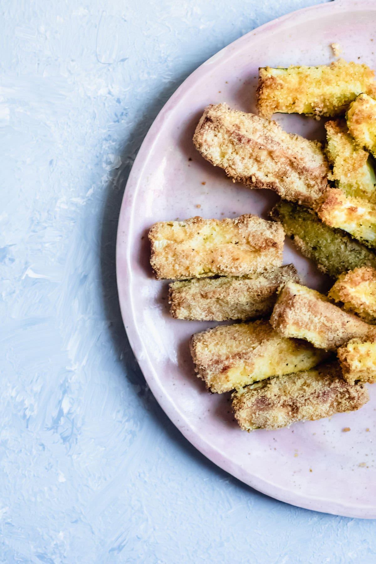 fried zucchini slices on a plate