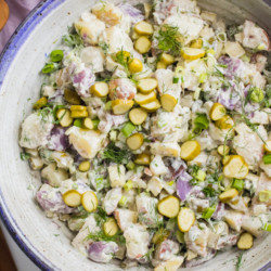 Crunchy dill pickles tossed together with creamy red, white, and blue potatoes, a huge handful of fresh dill and scallions. Dill pickle potato salad is quite literally THE BEST potato salad you will ever eat, for pickle lovers everywhere!