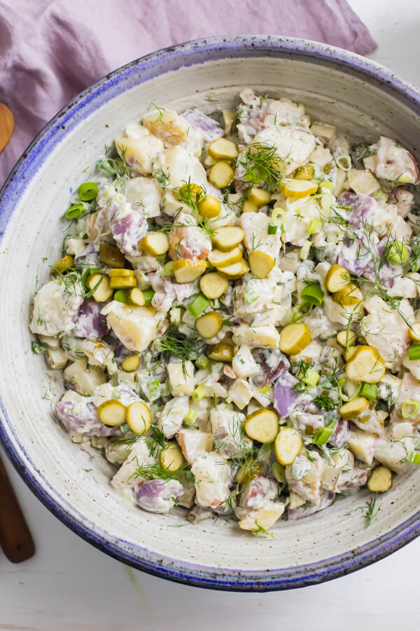 Crunchy dill pickles tossed together with creamy red, white, and blue potatoes, a huge handful of fresh dill and scallions. Dill pickle potato salad is quite literally THE BEST potato salad you will ever eat, for pickle lovers everywhere!