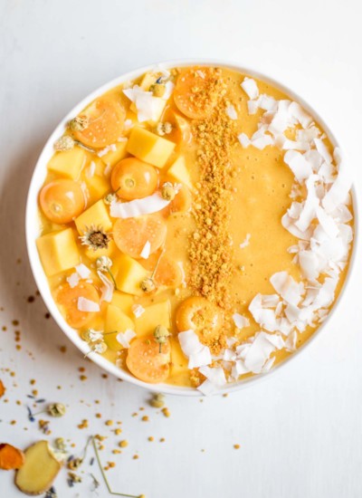 Fresh turmeric smoothie bowl, the perfect morning treat! Banana free! The creamy base is cauliflower, mango, lemon, orange, and a few other superfood ingredients to help you beat those seasonal allergies. So yummy!