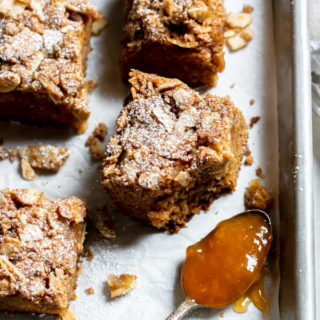 close up shot of apricot almond coffee cake on sheet tray with spoonful of apricot jam