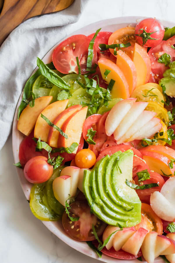 A fresh heirloom tomato salad with juicy sweet peaches, creamy avocado, and fresh herbs. This healthy, simple salad is the very representation of savoring the final weeks of summer using only seasonal local produce. 