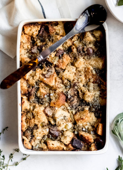 Sourdough Stuffing with Wild Mushrooms in white platter with spoon
