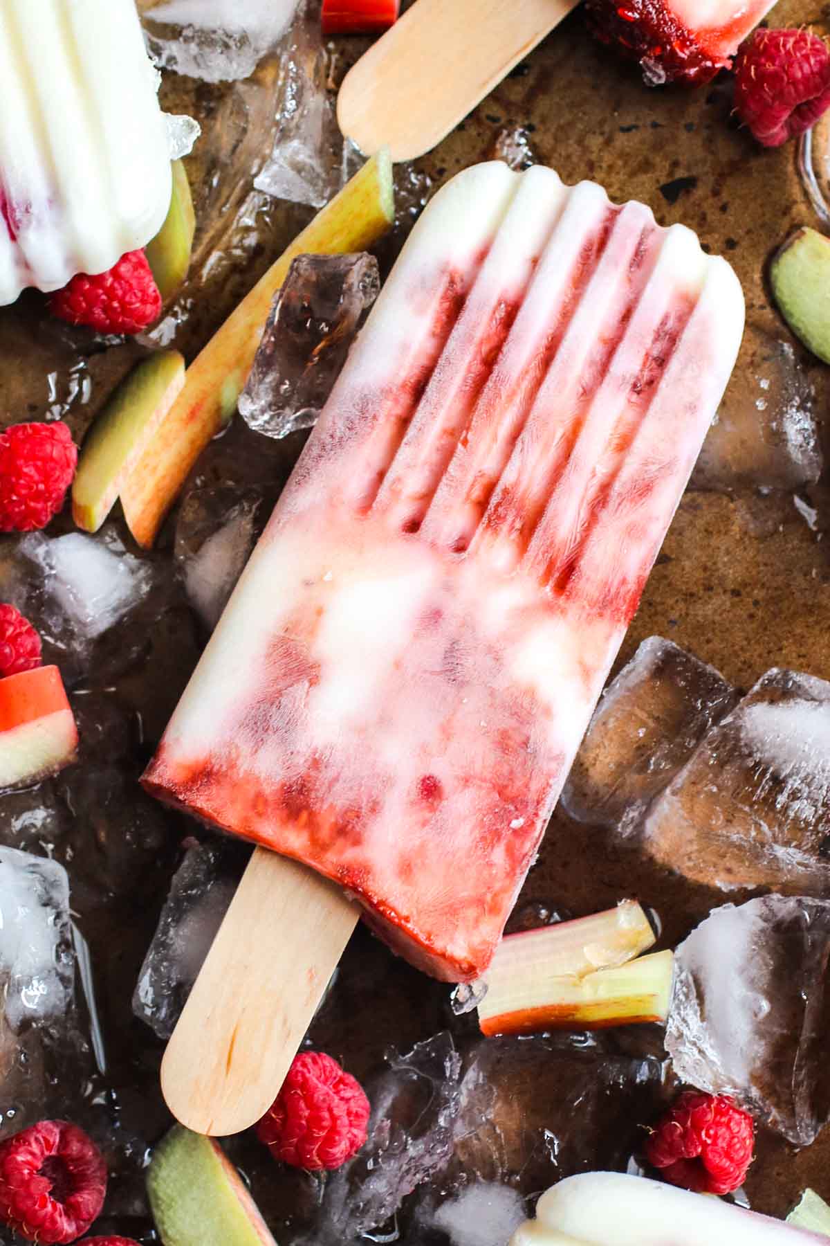 Homemade creamy yogurt popsicles with raspberry rhubarb swirl. A healthy snack, quick breakfast and only 84 calories!