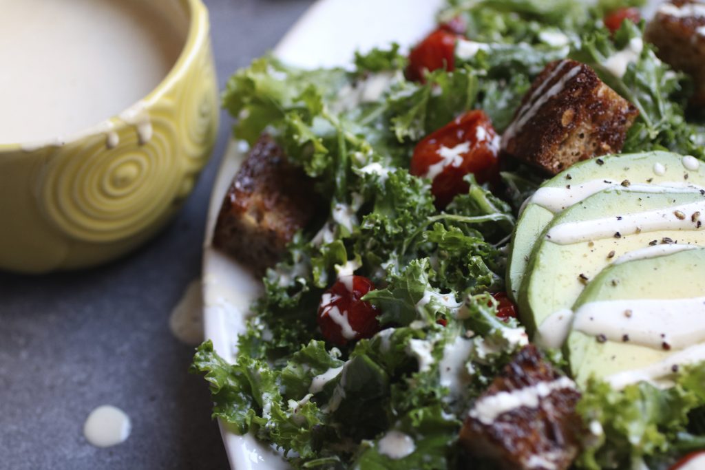 This vegan Kale Caesar Salad with roasted tomatoes and creamy avocado is easy to make super healthy and nourishing. |abraskitchen.com