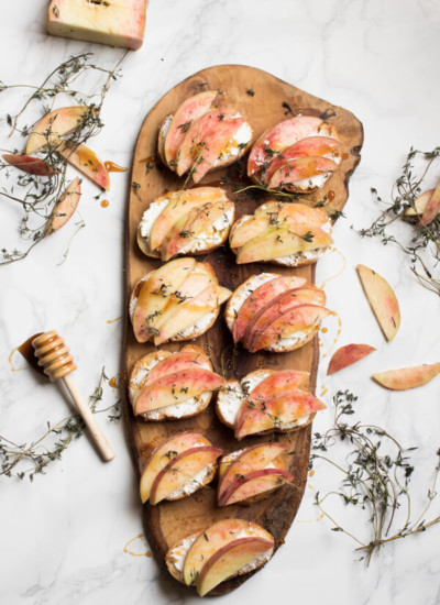 Peach goat cheese crostini is the perfect little bite on a hot summer's day. Creamy goat cheese topped with fresh juicy peaches, earthy thyme, and a drizzle of honey. Appetizer, peach, vegetarian, healthy | abraskitchen.com