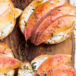 Peach goat cheese crostini is the perfect little bite on a hot summer's day. Creamy goat cheese topped with fresh juicy peaches, earthy thyme, and a drizzle of honey. Appetizer, peach, vegetarian, healthy | abraskitchen.com