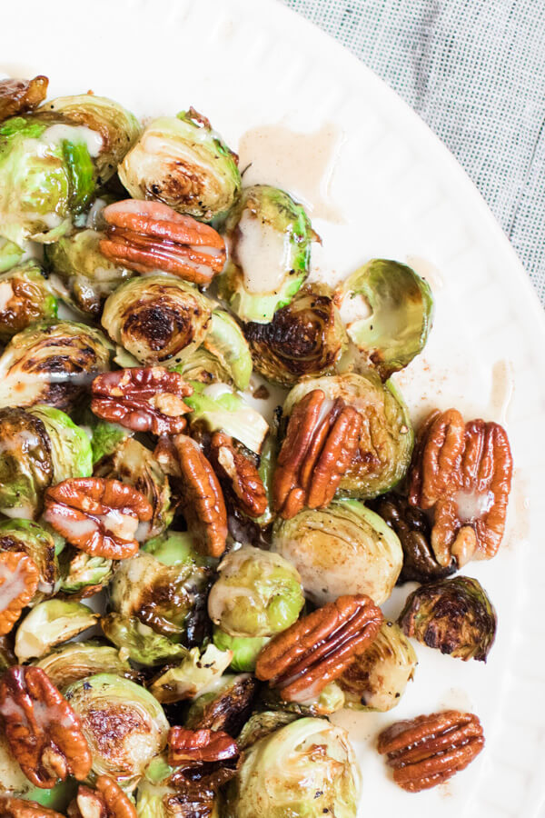 Gorgeous roasted Brussels sprouts tossed with crunchy pecans in a brown butter sauce and drizzled with a spiced maple tahini glaze. Gluten free, Paleo. 