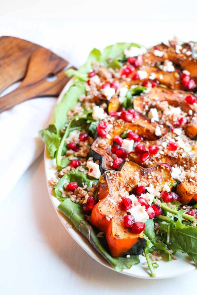 This festive (gluten free) Roasted Acorn Squash Salad with warm Buckwheat, Five-Spice Acorn Squash, Feta Cheese, and Pomegranate Seeds is full of healthy seasonal ingredients and a sweet and tangy maple dijon dressing. Yum! |Abraskitchen.com