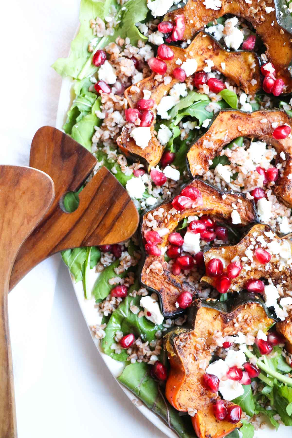 This festive (gluten free) Roasted Acorn Squash Salad with warm Buckwheat, Five-Spice Acorn Squash, Feta Cheese, and Pomegranate Seeds is full of healthy seasonal ingredients and a sweet and tangy maple dijon dressing. |Abraskitchen.com