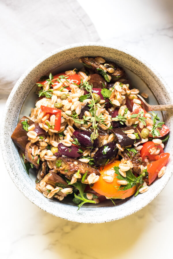Nutty chewy (and super healthy) farro meet a bounty of fresh herbs, perfectly roasted eggplant, garden fresh tomatoes, and lots of kalamata olives! All tossed together in a garlic vinaigrette. This healthy vegan grain salad is easy enough to prepare and so delicious!