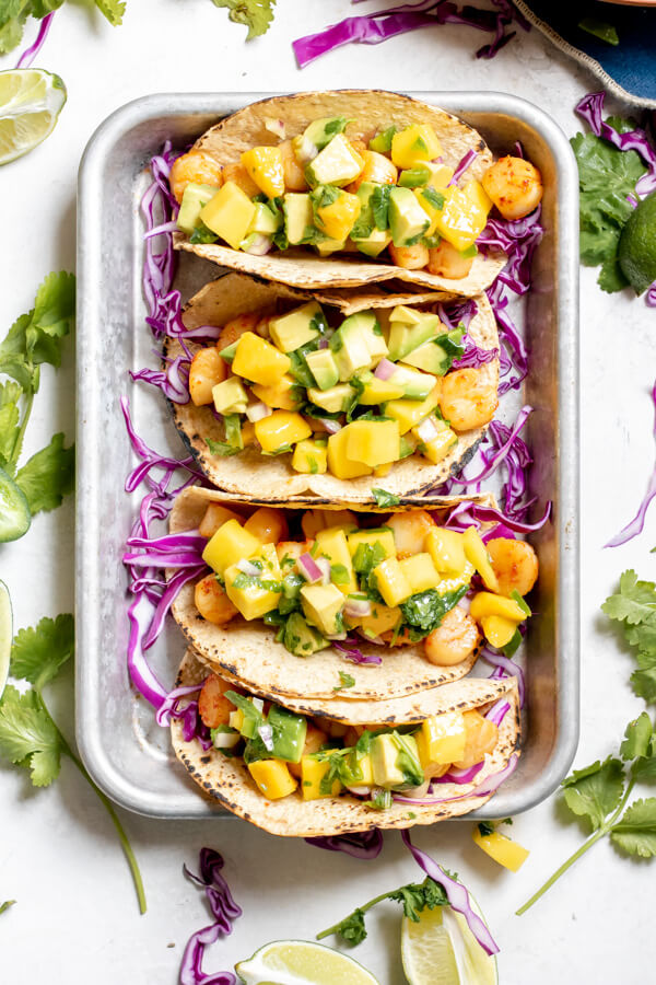 Seared Scallop Tacos with Mango Avocado Salsa on a sheet tray on a white background