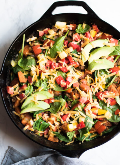 Southwestern sweet potato and ground beef skillet is loaded with fresh veggies and topped with cheese and avocado. A healthy, easy, and delicious dinner that your whole family will love. Ready in 30 minutes! Gluten Free. Real Food.