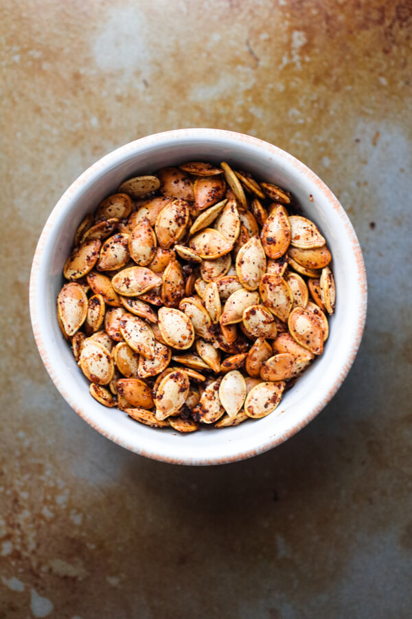Perfectly roasted seeds from acorn, butternut, spaghetti, or delicata squash. Salty, crunchy, spicy and addictively delicious. Also full of nutrients and minerals! |abraskitchen.com #roastedseeds #pumpkinseeds 