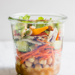 Healthy Thai Chickpea Jar Salad is the perfect meal prep lunch, this recipe makes 4 days of crazy town delicious protein-rich lunches! Creamy spicy peanut butter dressing with chickpeas, crunchy vegetables, cilantro, and salted peanuts. You have to put this on your meal plan!