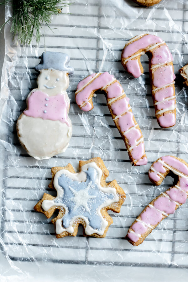 holiday sugar cookies made with almond flour on a cooling rack, iced with natural frosting