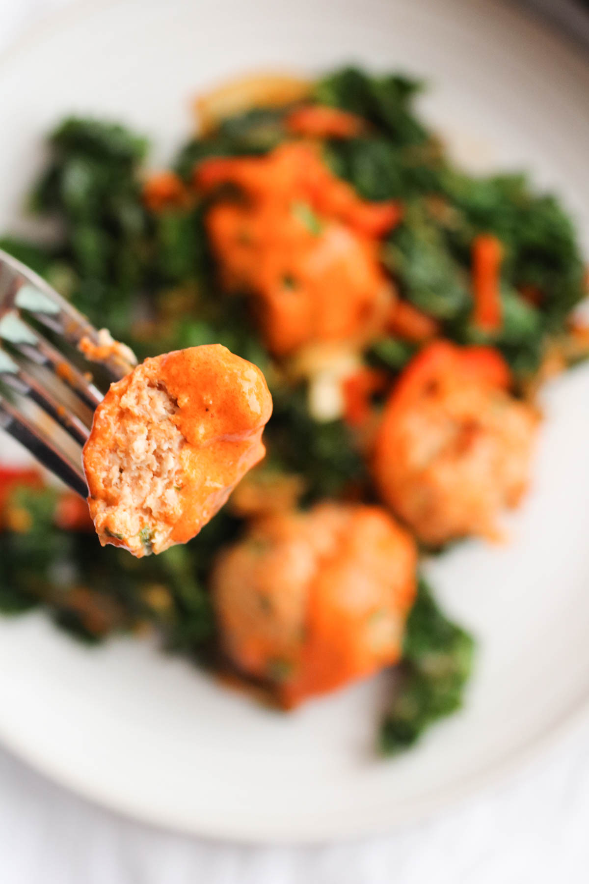 The best chicken meatballs in a creamy roasted red pepper feta cheese sauce with sauteed kale. OMG, so good!
