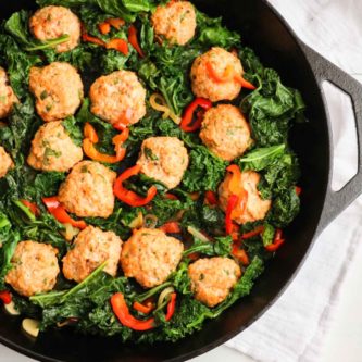 The BEST chicken meatballs in a creamy roasted red pepper feta cheese sauce with sauteed kale. One skillet and OMG, so good! |Abraskitchen.com