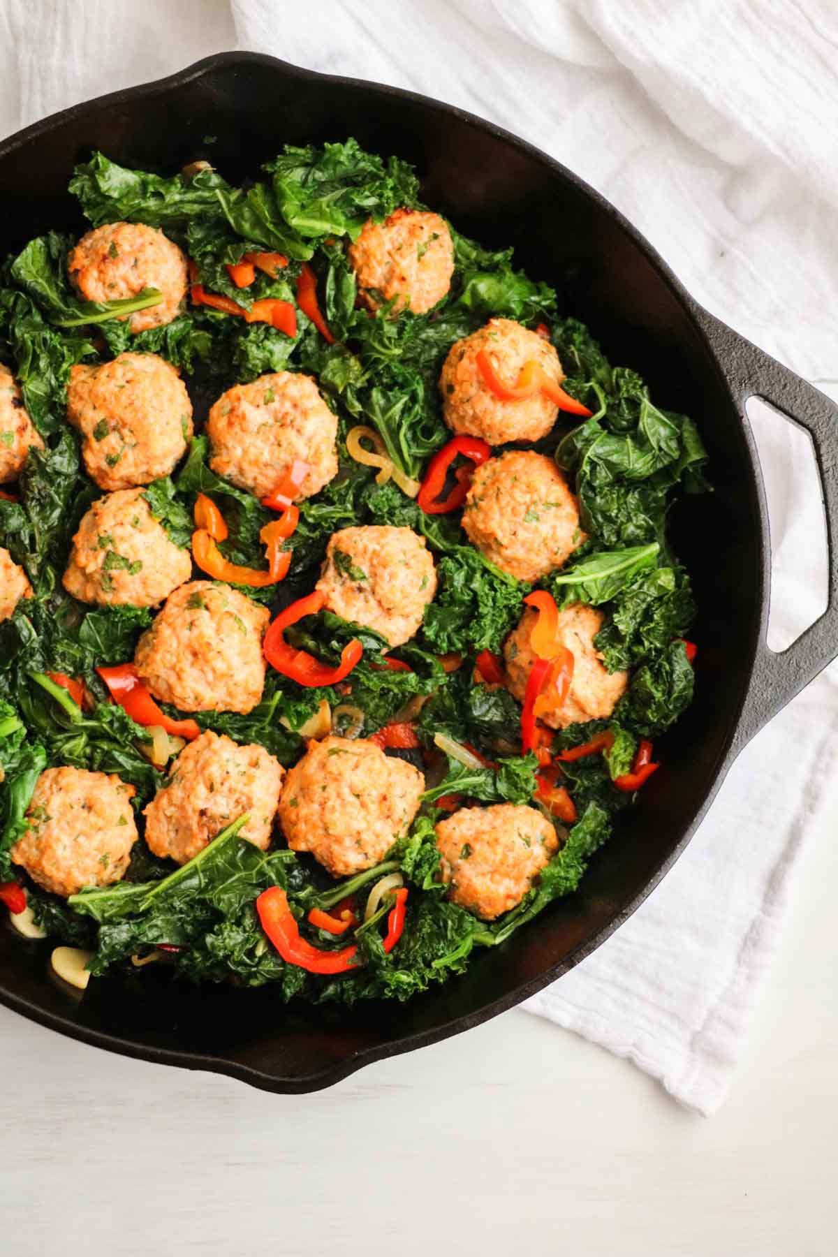 The BEST chicken meatballs in a creamy roasted red pepper feta cheese sauce with sauteed kale. One skillet and OMG, so good! |Abraskitchen.com