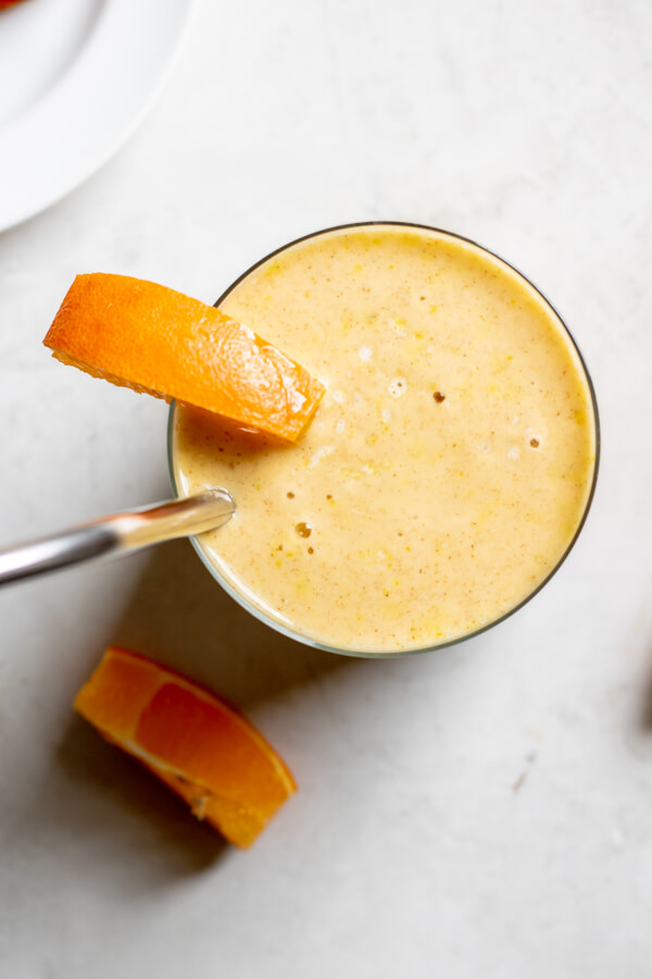 Turmeric Glow Up Smoothie in a glass on a white background