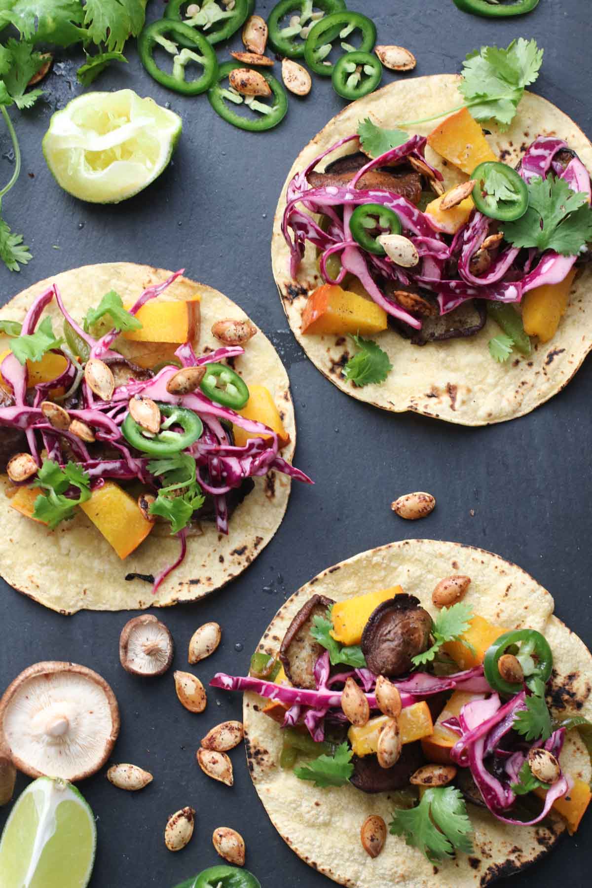 Vegan pumpkin shitake tacos combine creamy pumpkin and earthy shitake mushrooms with a crunchy-creamy lime slaw and perfectly spiced pumpkin seeds. This healthy recipe is done in 40 minutes flat! |abraskitchen.com